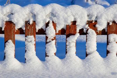 Close-up of snow covered landscape against blue sky