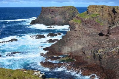 Rock formations by sea against sky
