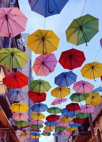 Low angle view of umbrellas hanging against sky