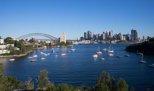 Boats in sea with buildings in background
