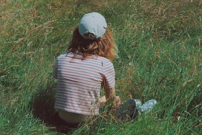 Rear view of girl sitting on grassy field