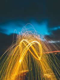 Wire wool against sky at night