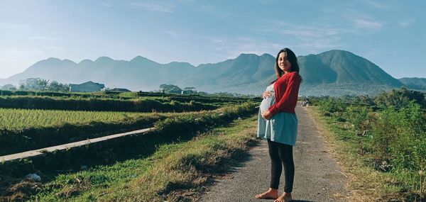 Woman standing on mountain against sky