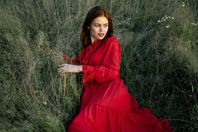 Portrait of young woman standing on field