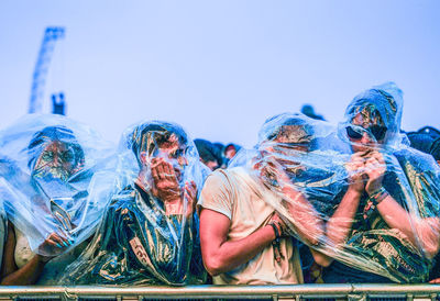 Close-up of people against clear blue sky
