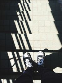 Low section of man standing on tiled floor