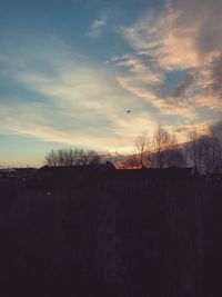 Silhouette of fence against dramatic sky