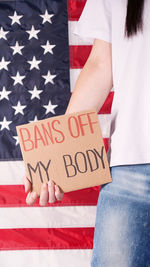 Midsection of woman holding american flag