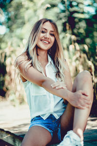 Portrait of smiling young woman sitting outdoors