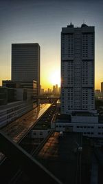 Buildings in city against sky during sunset