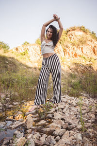 Full length of young woman standing on ground