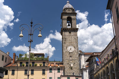 Low angle view of clock tower amidst buildings against sky