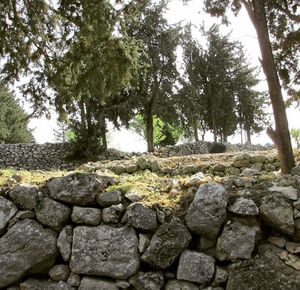 Stones by stone wall against sky