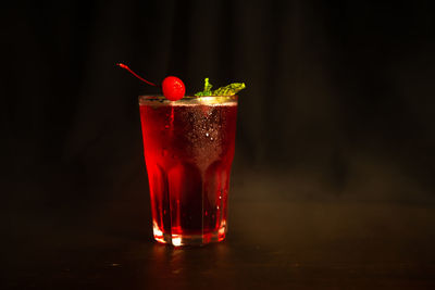 Close-up of glass of juice against black background