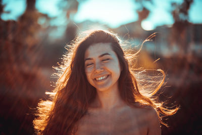 Smiling young woman standing at beach