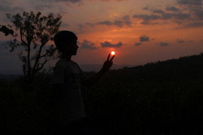 Silhouette man standing against sky during sunset