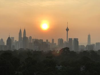 View of skyscrapers in city during sunset