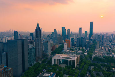 Aerial view of buildings in city during sunset