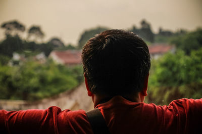 Rear view of man looking at view against sky