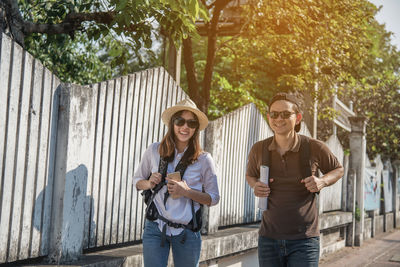 Smiling couple walking on footpath in city