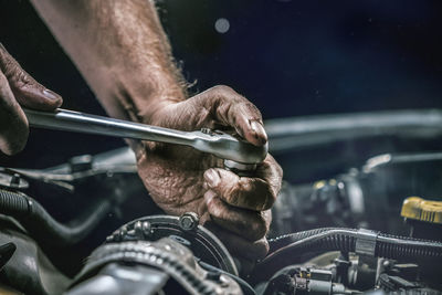 Close-up of man repairing engine