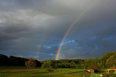 Scenic view of rainbow over landscape against sky