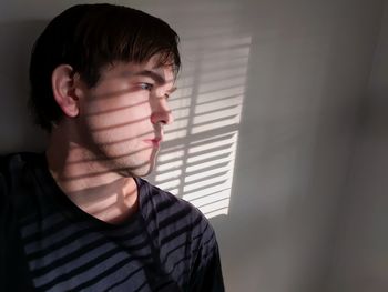 Portrait of young man looking away at home