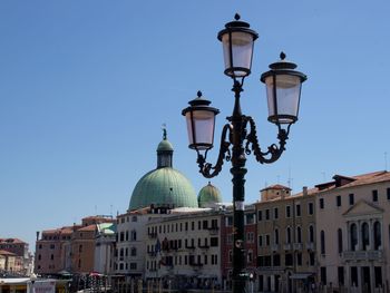 Low angle view of church and street light against clear blue sky