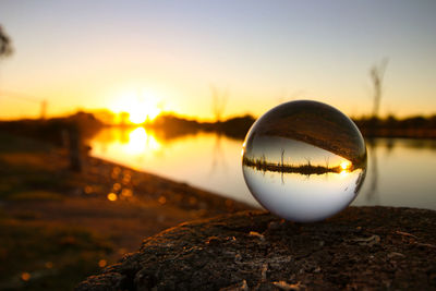 Close-up of crystal ball with reflection in lake