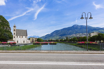 Street by road against buildings in city against sky