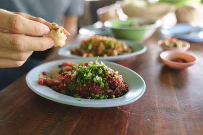 Midsection of person eating food on table