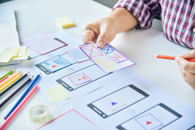 Midsection of man holding paper at creative office