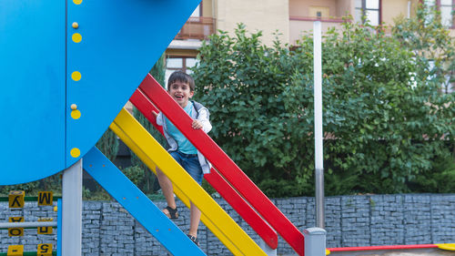 Full length portrait of boy climbing outdoors