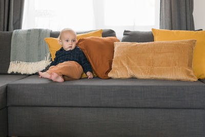 Young woman sitting on sofa at home