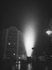 Illuminated street light in city at night