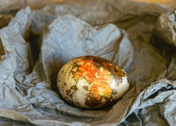 Variegated, painted and decorated easter egg on a background of crumpled paper