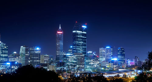 Illuminated buildings in city against sky at night