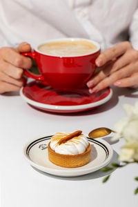 Midsection of woman having breakfast on table