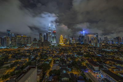 High angle view of illuminated buildings against sky at night