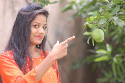 Portrait of young woman against tree