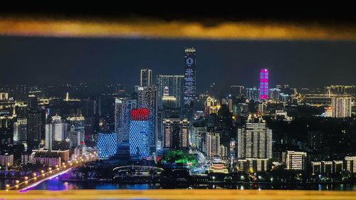 Illuminated cityscape against sky at night