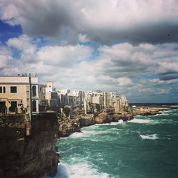 View of cityscape against cloudy sky