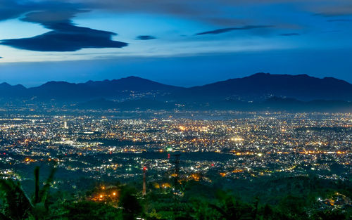 High angle view of city lit up at night