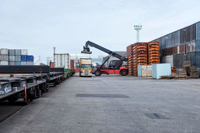 Vehicles on pier against sky