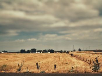 Scenic view of field against cloudy sky