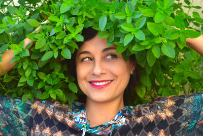 Close-up of smiling woman by plants
