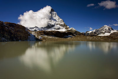 Scenic view of lake and snowcapped mountains against sky