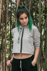 Portrait of young woman standing in forest