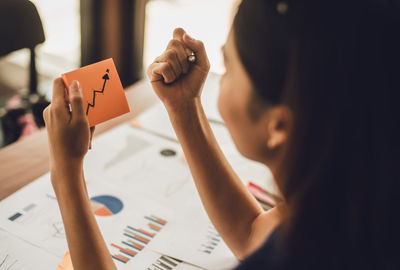 Woman holding adhesive note at office