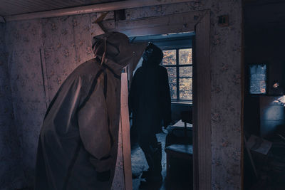 Rear view of woman standing against wall